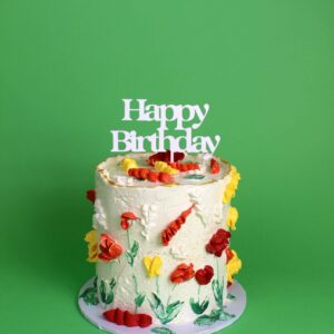A birthday cake decorated with flowers and a 'Happy Birthday' sign on a green background. floral cake, floral piping, birthday cake, celebration cake